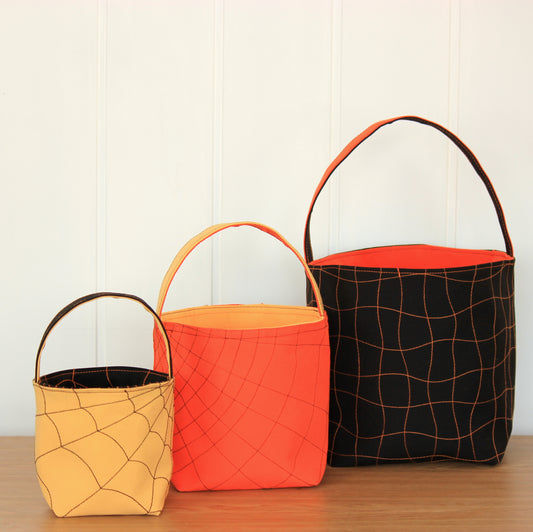 Three Halloween-themed fabric buckets in orange, red, and black - sewing tutorial with templates by NatkoPatterns