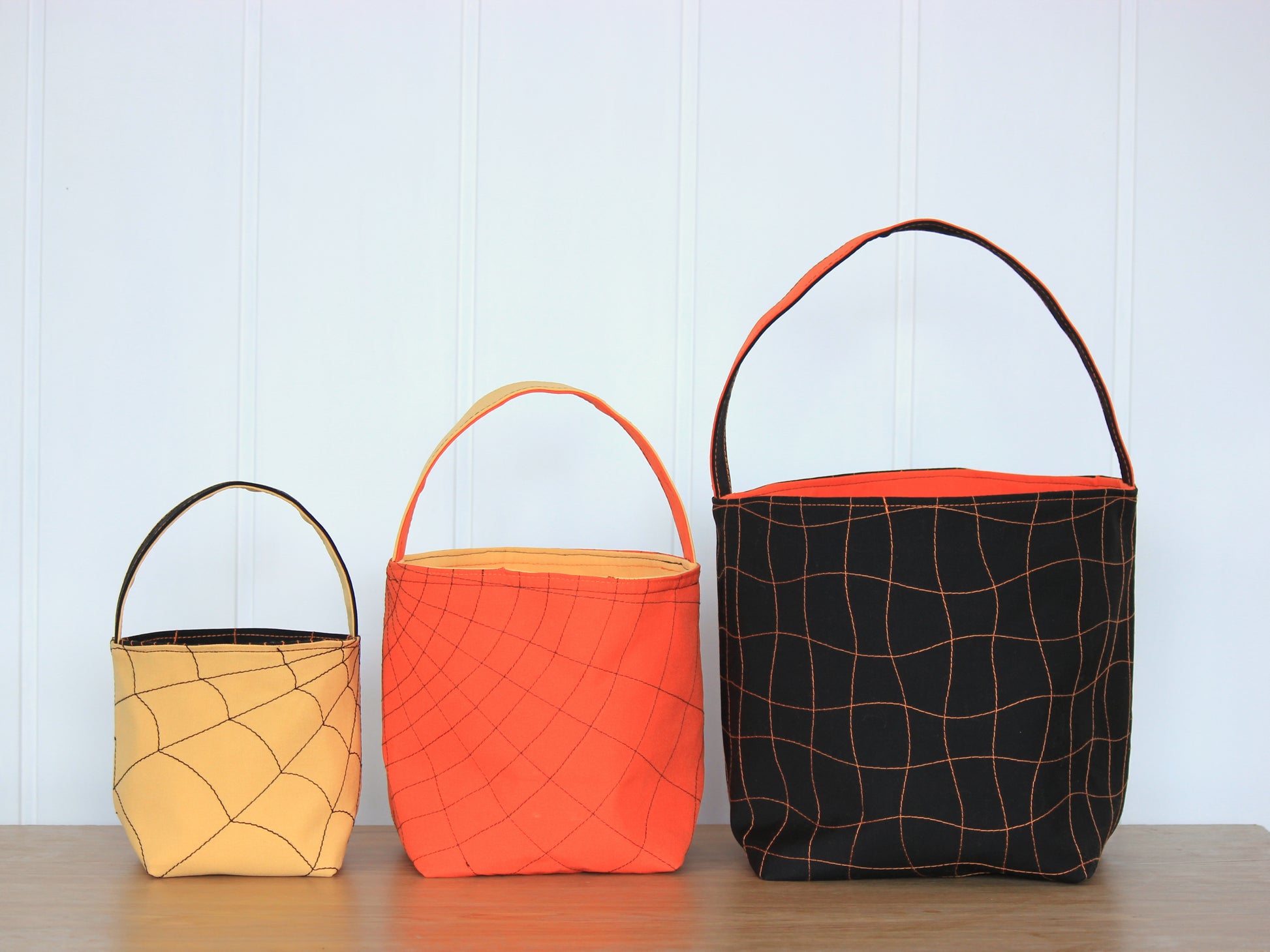 Three fabric buckets in orange, red, and black with spider web patterns - sewing project by NatkoPatterns