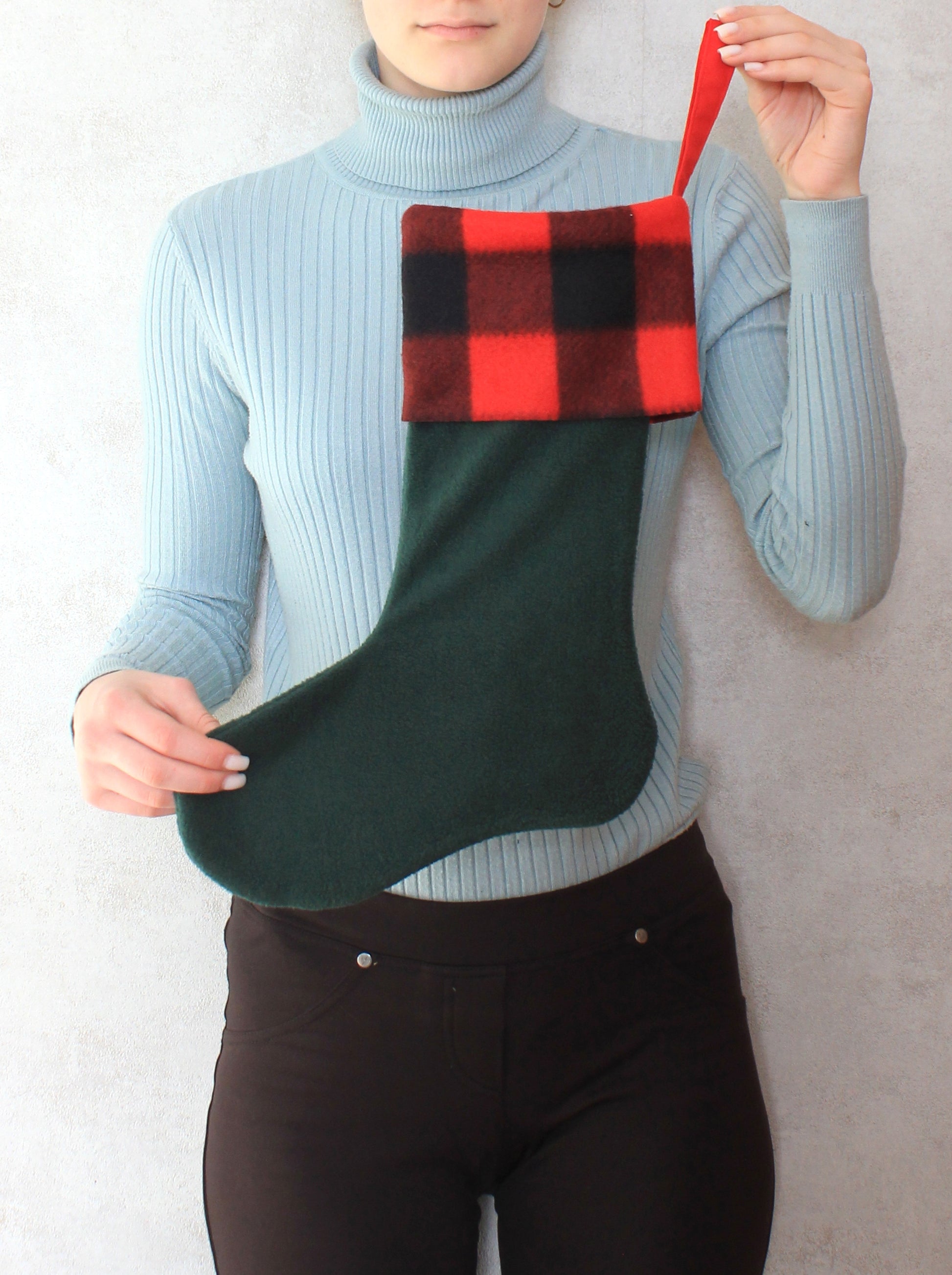 Person holding a green and red plaid Christmas stocking - sewing pattern