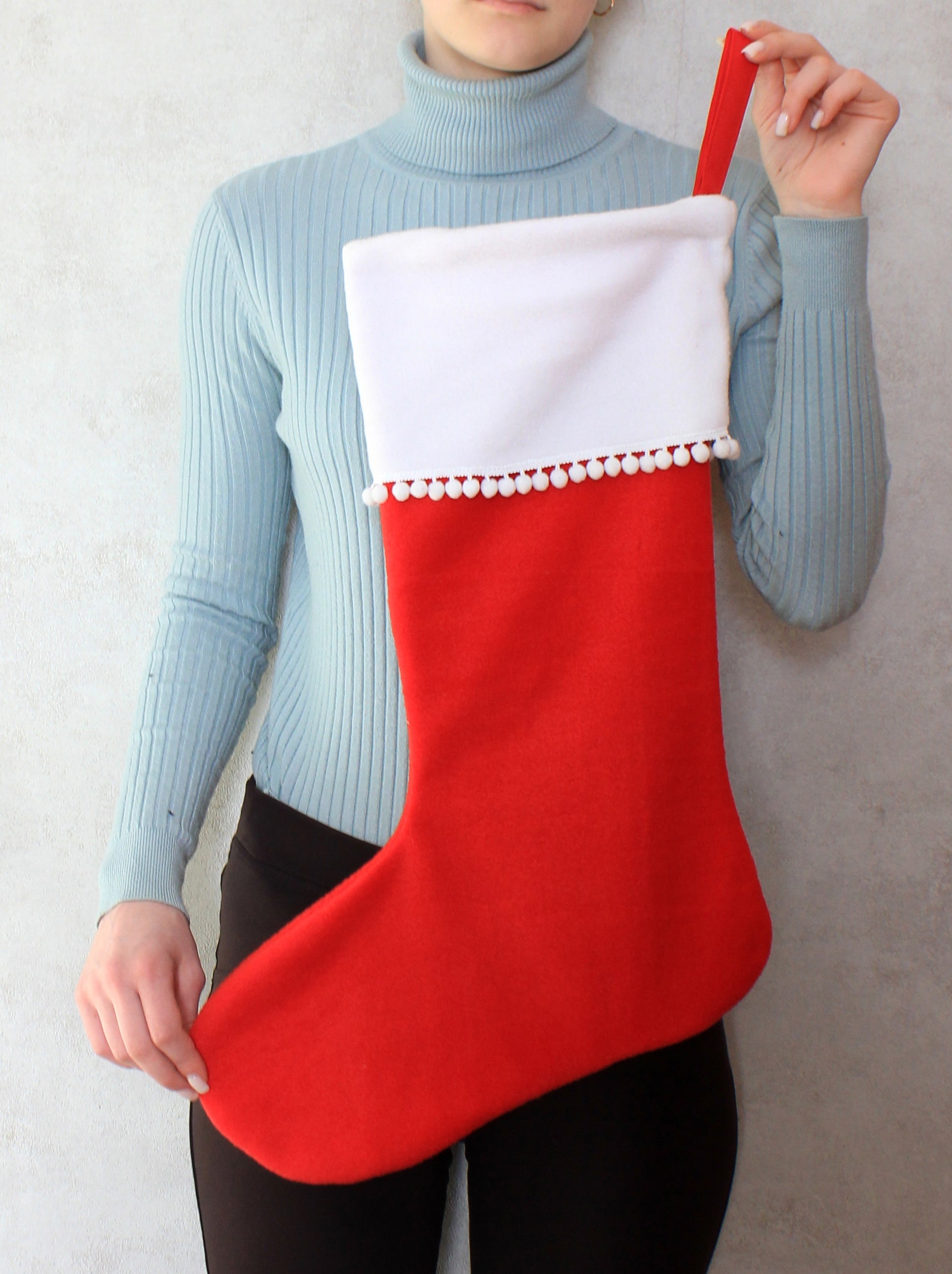 Person holding a red and white Christmas stocking - sewing pattern with template