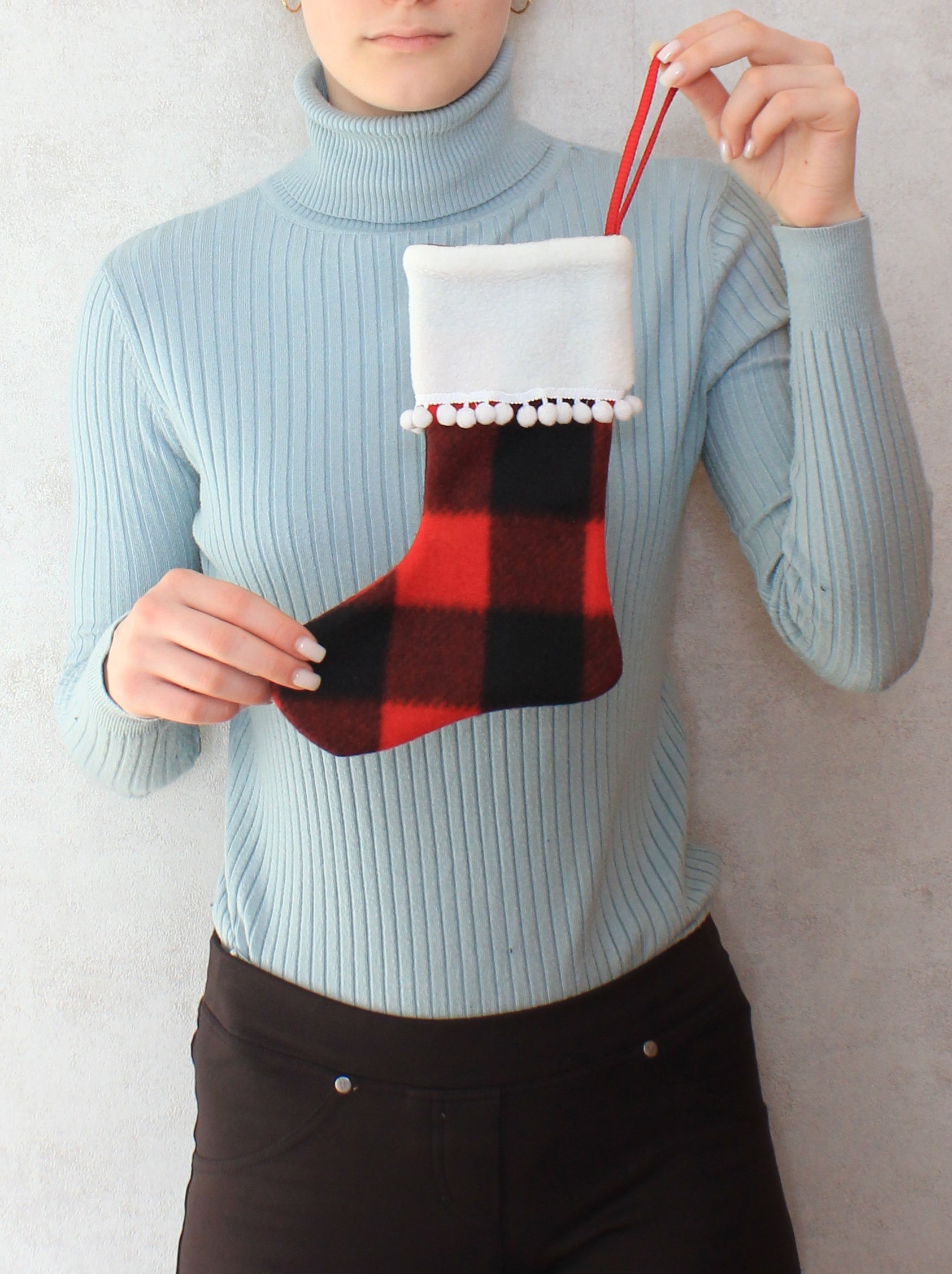 Person holding a red and black checkered stocking easy sewing pattern and temates by NatkoPatterns