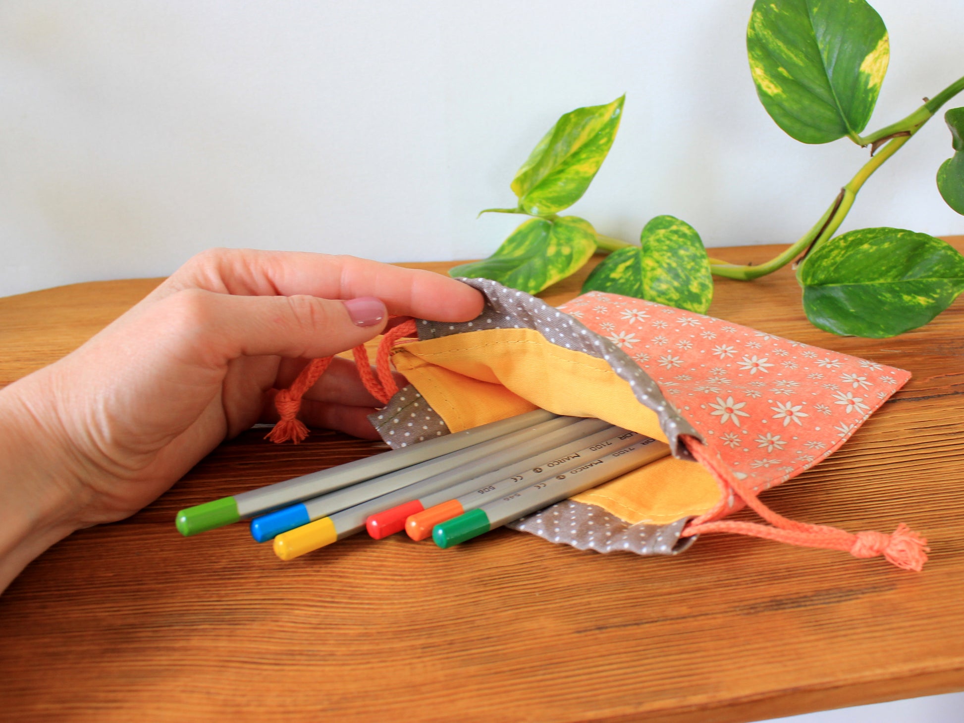 Hand holding a set of colorful markers with a small drawstring bag - sewing pattern by NatkoPatterns