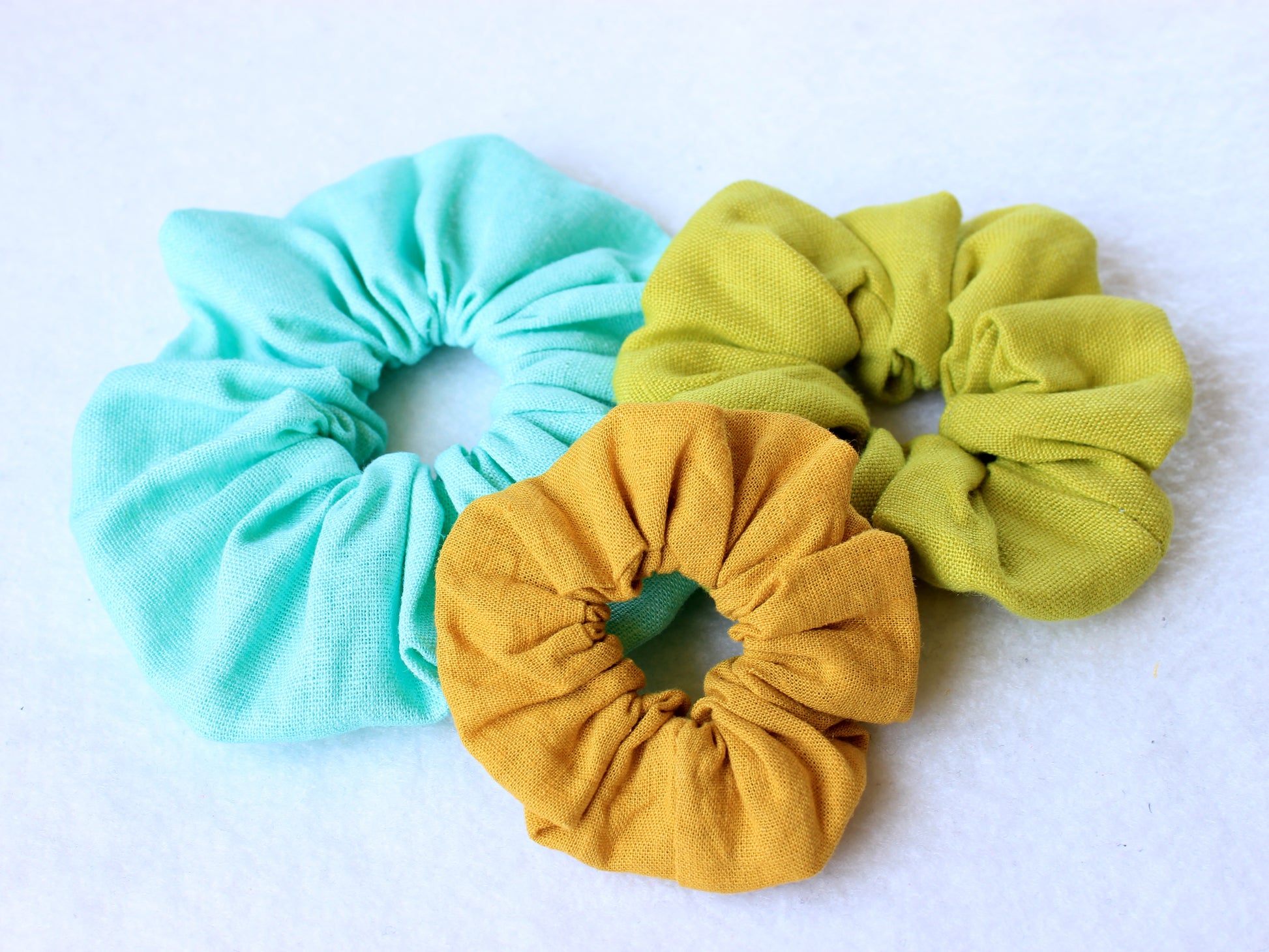 Three linen scrunchies (blue, yellow, green) sewing with pattern by NatkoPatterns