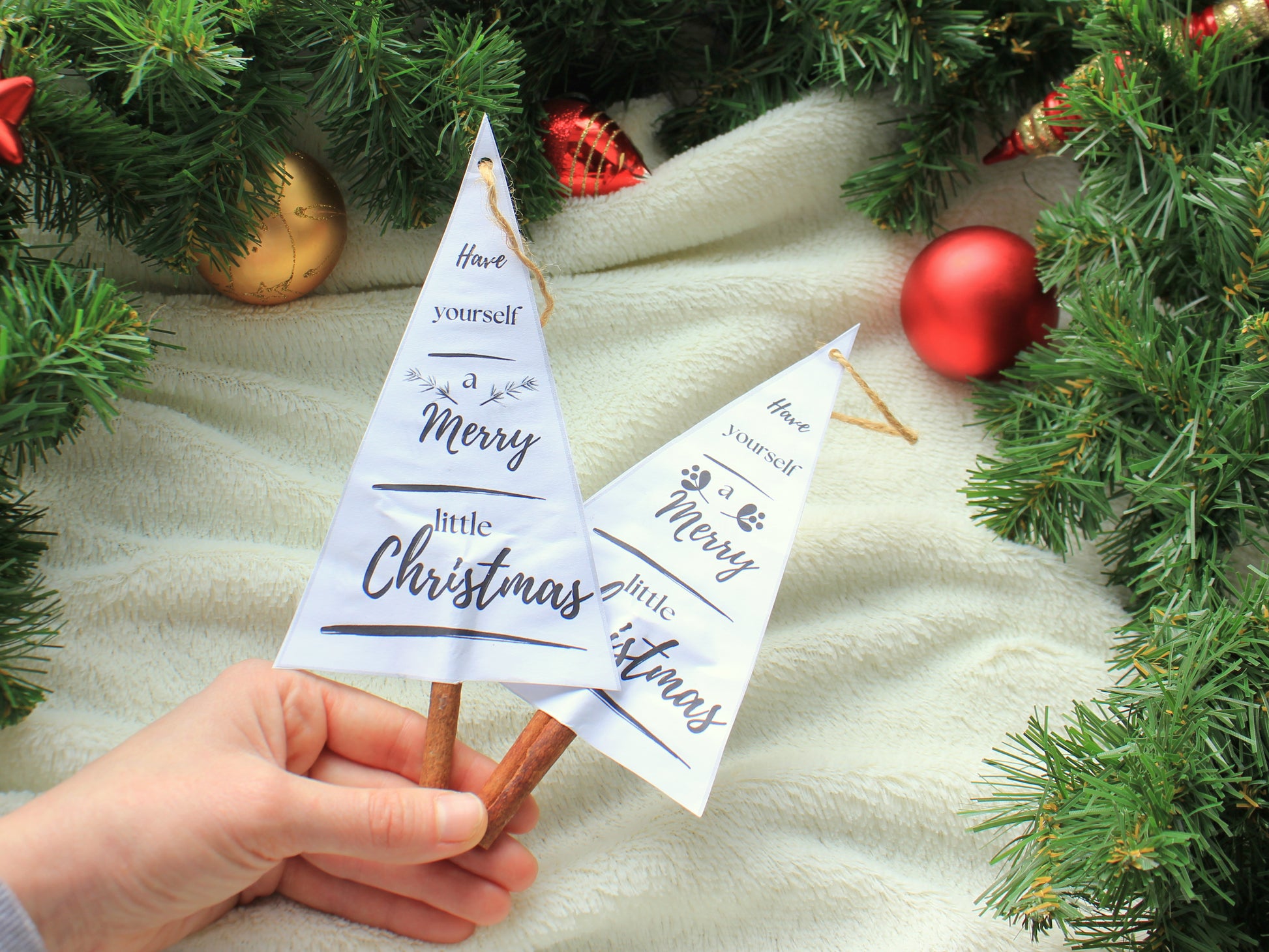 Hand holding a small Christmas tree-shaped card with decorative elements - handmade decor