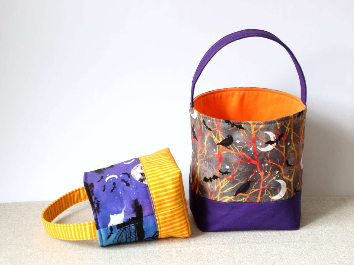 Halloween fabric basket lying on its side, showing the purple exterior fabric and contrasting yellow bottom.