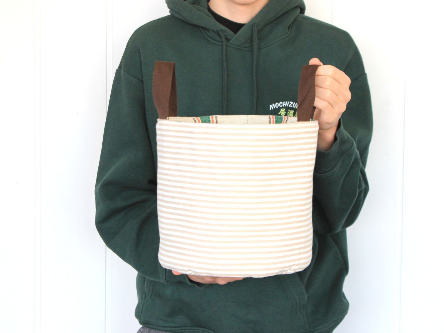 L round fabric basket made with the NatkoPatterns sewing pattern, shown in hand to illustrate the finished size