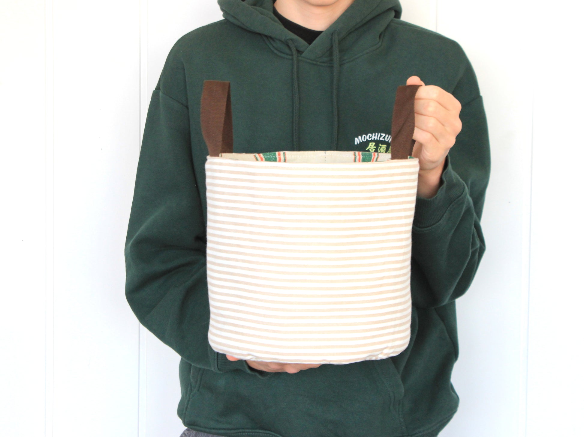 L round fabric basket made with the NatkoPatterns sewing pattern, shown in hand to illustrate the finished size