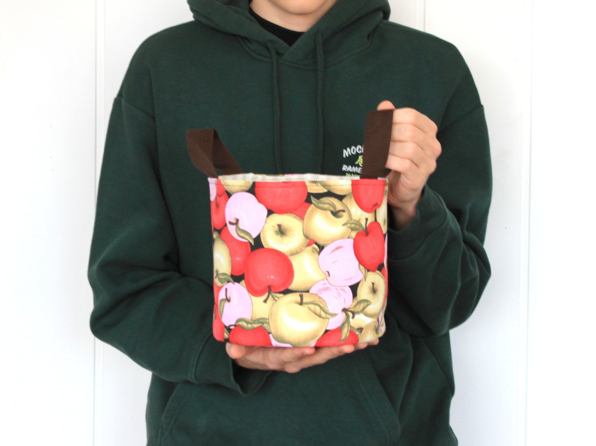 M round fabric basket made with the NatkoPatterns sewing pattern, shown in hand to display the finished size
