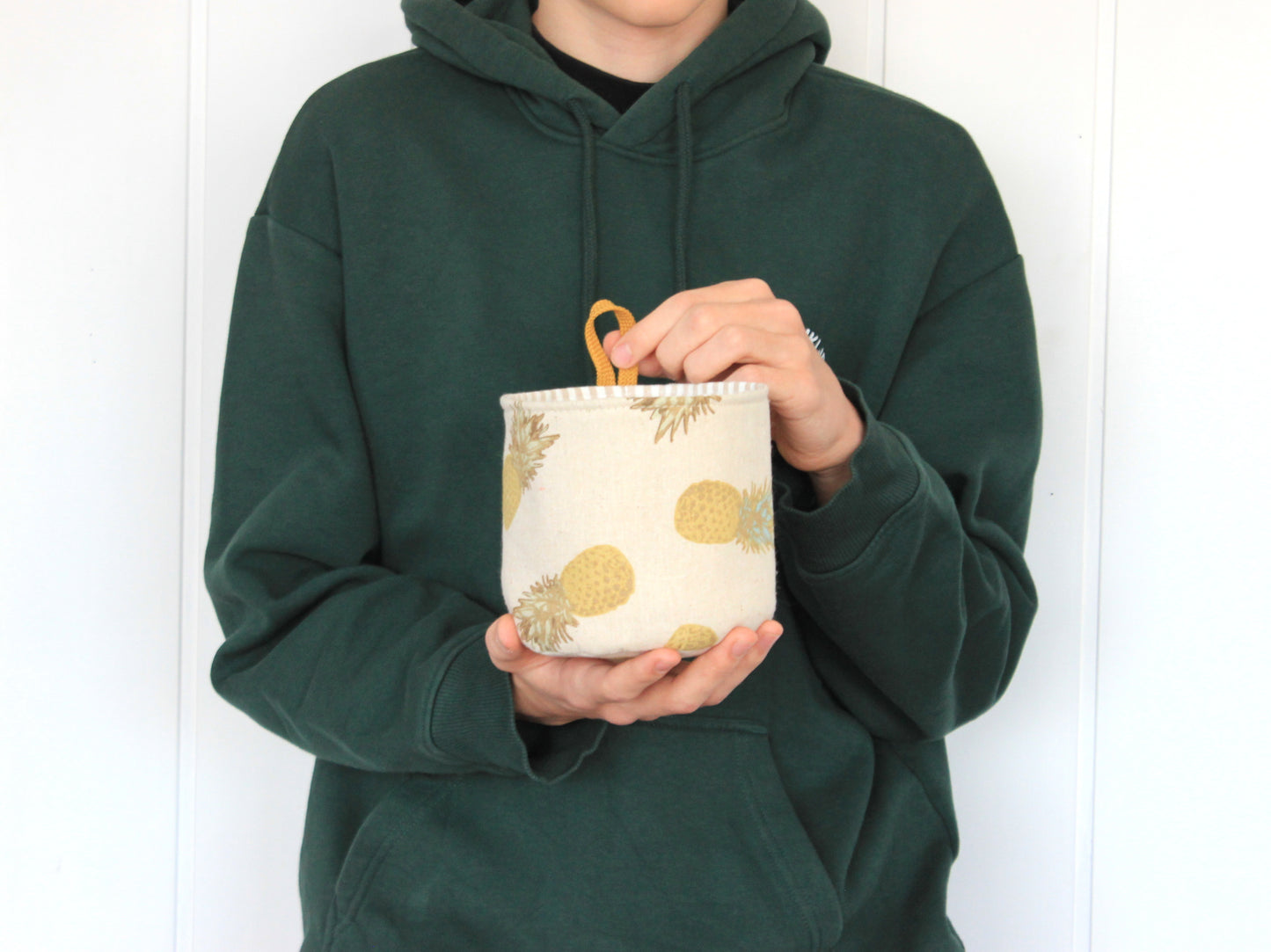 S round fabric basket made with the NatkoPatterns sewing pattern, shown in hand for size reference