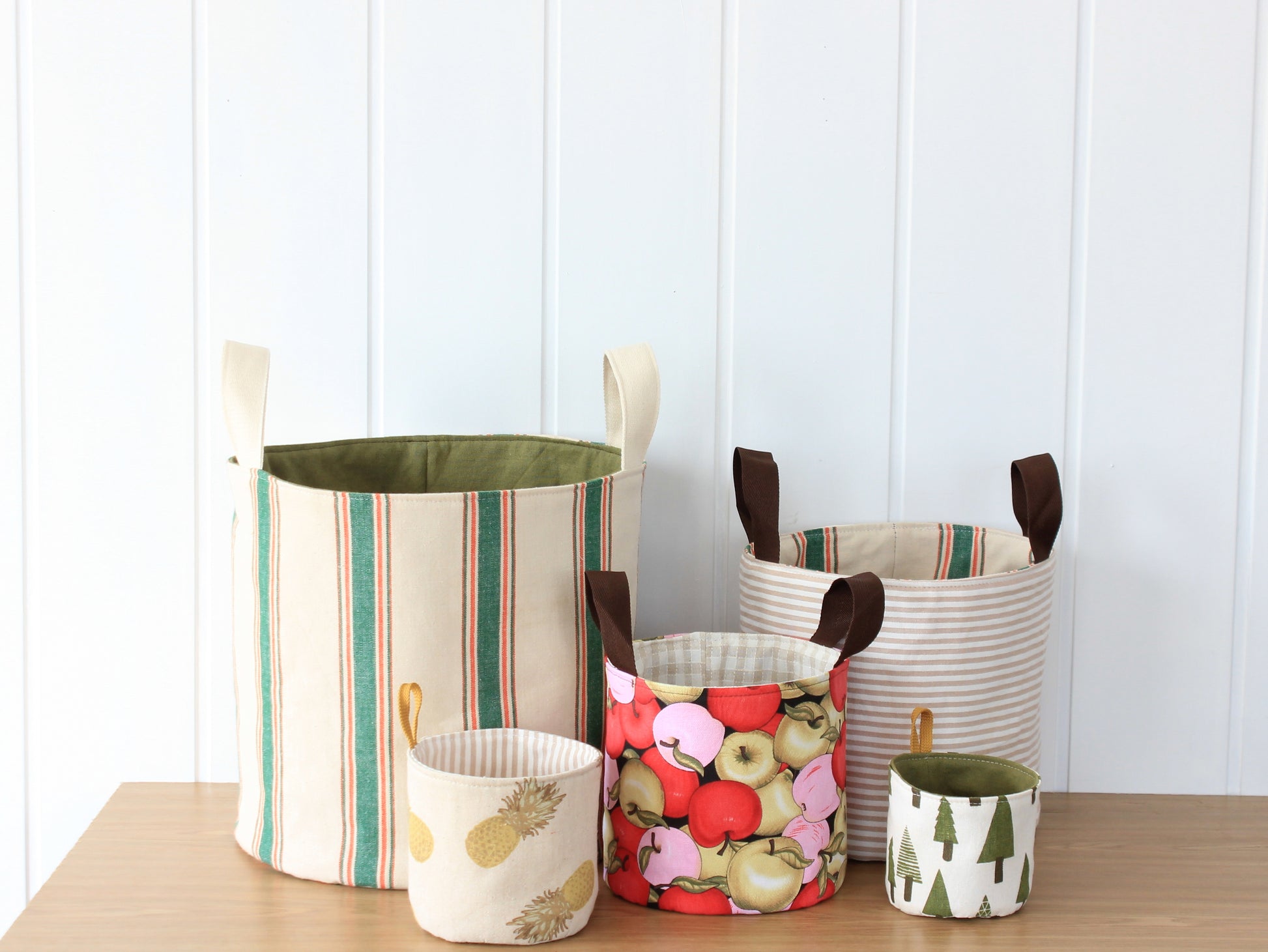 Five reversible fabric baskets sewn with the NatkoPatterns Round Fabric Basket sewing pattern in graduated sizes